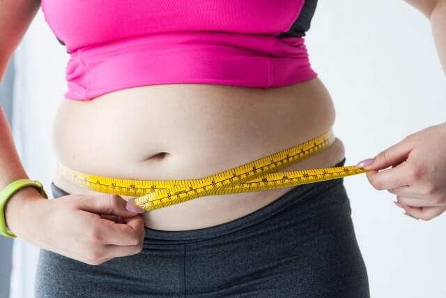 ウエストを測る肥満女性